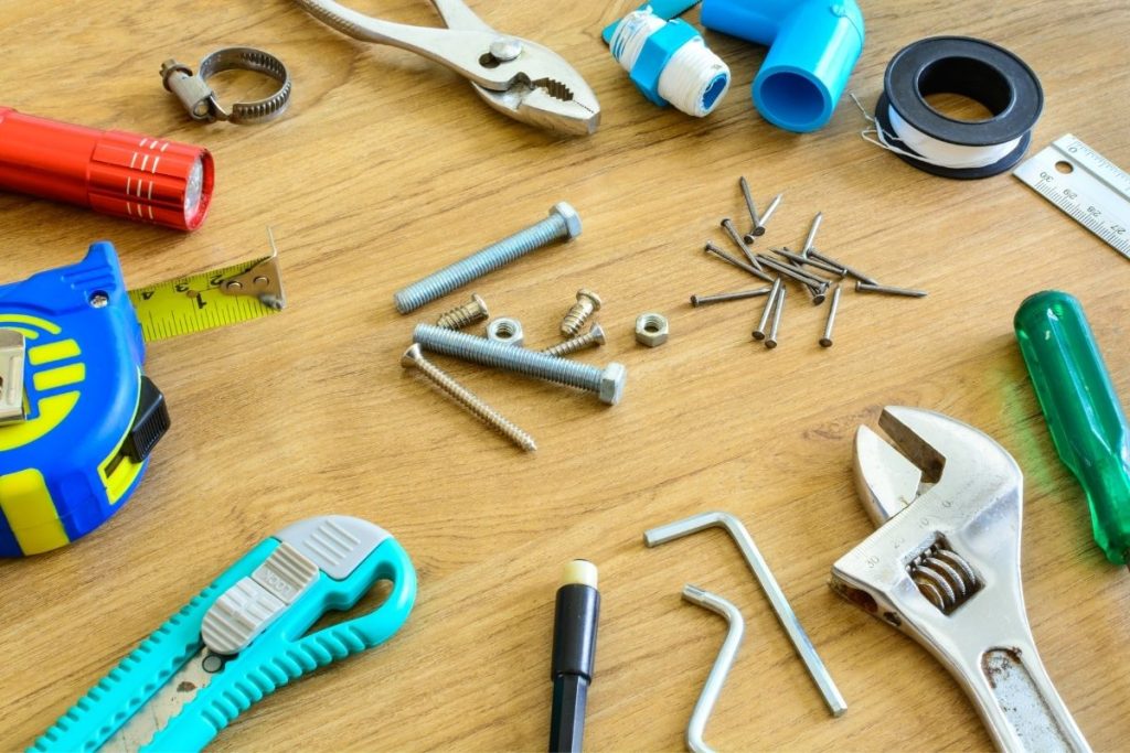 A wooden table displaying various tools, including hammers, wrenches, and screwdrivers, arranged neatly for use.